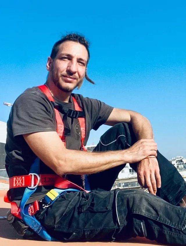 Igor Gabriielian in a safety harness on a construction-site rooftop